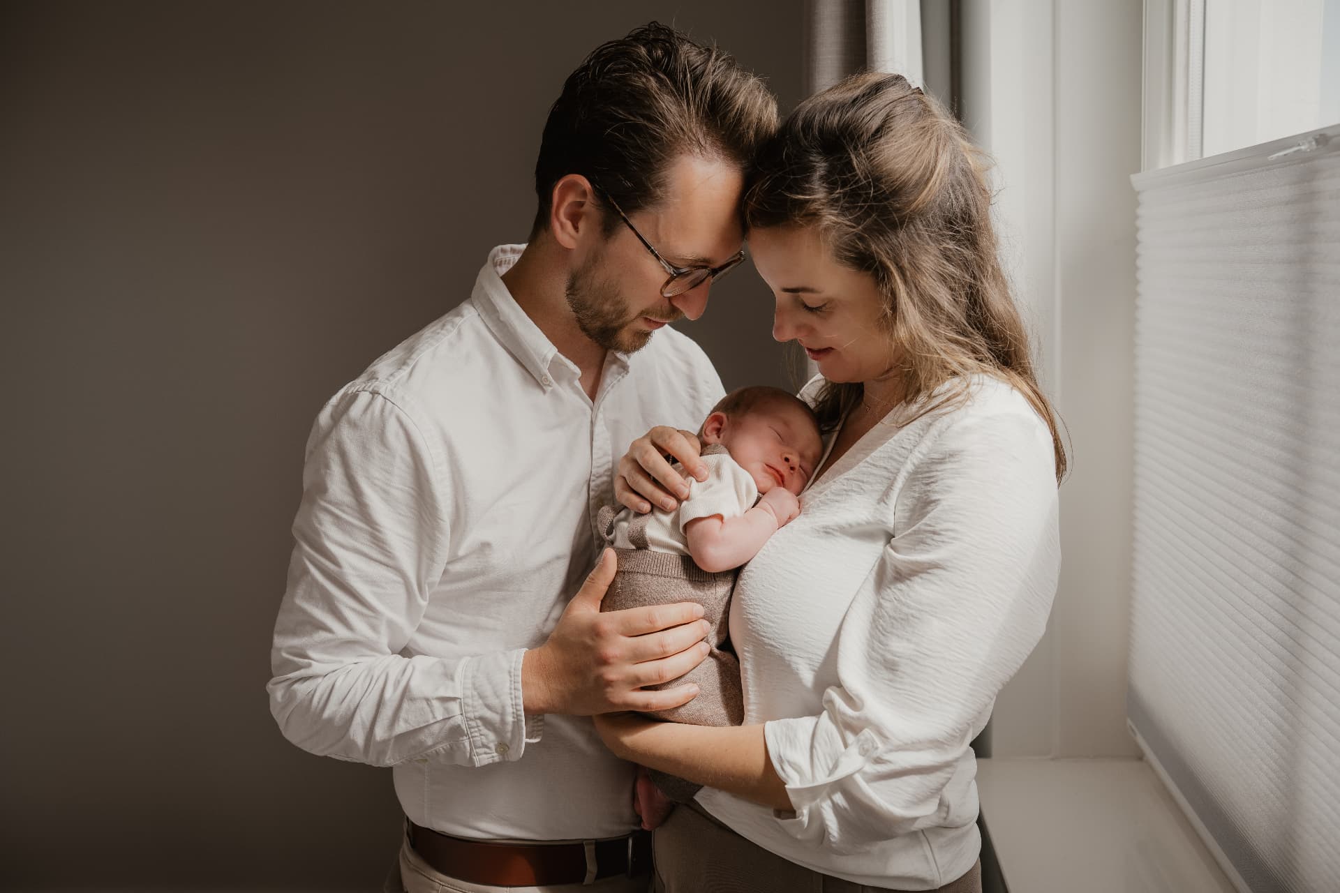 Ouders houden hun pasgeboren baby teder vast